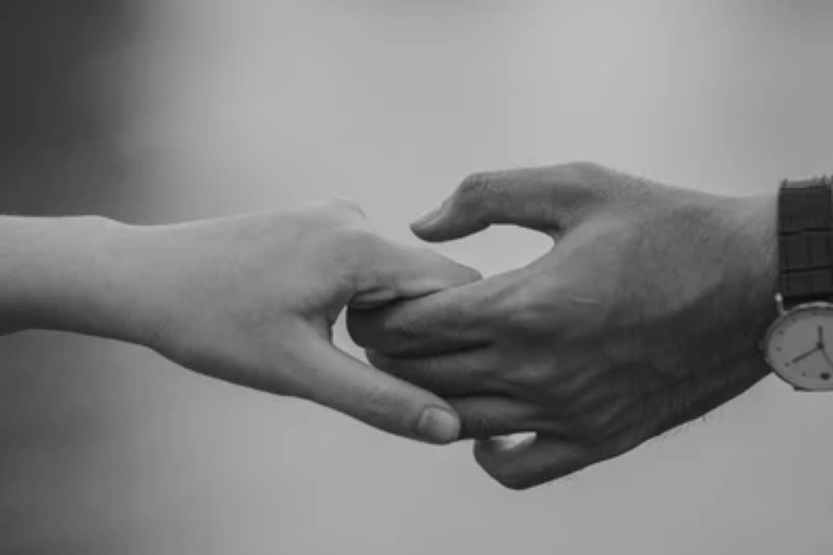 Black and white image of a couple gently holding hands, symbolising intimacy, connection, and emotional closeness. libido and relationships in midlife.